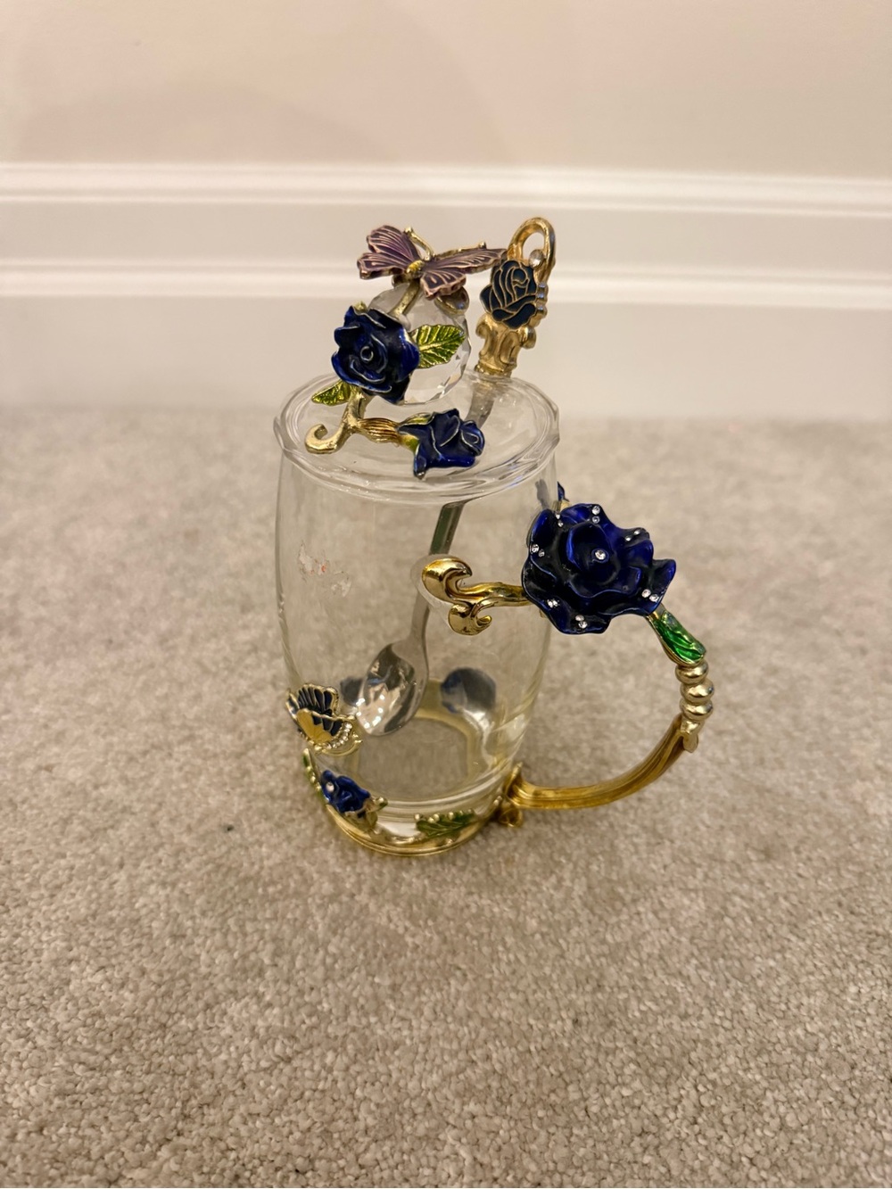 Glass mug with gold coloured handle lid and spoon